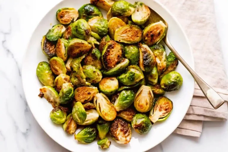 A plate of roasted Brussels sprouts with crispy edges.